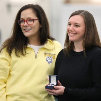 President Jacqueline Edmondson presents track star Emily Artesani Walton with a ring signifying her induction into the Little East Hall of Fame.