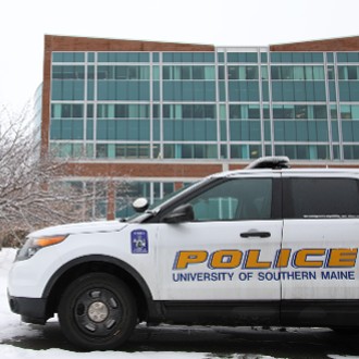 A USM Police cruiser waits for its driver in a parking space beside the Science Building.