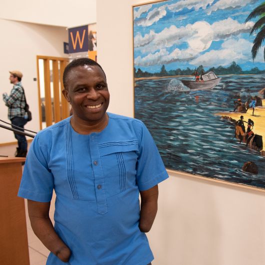 Frederick Ndabaramiye meets his admirers at a reception amid an exhibition of his paintings at the Lewiston-Auburn Campus' Atrium Gallery.