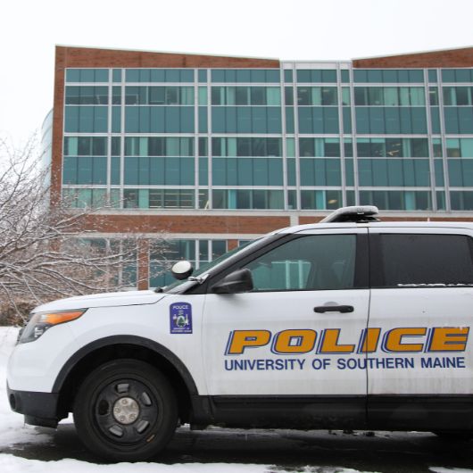 A USM Police cruiser waits for its driver in a parking space beside the Science Building.