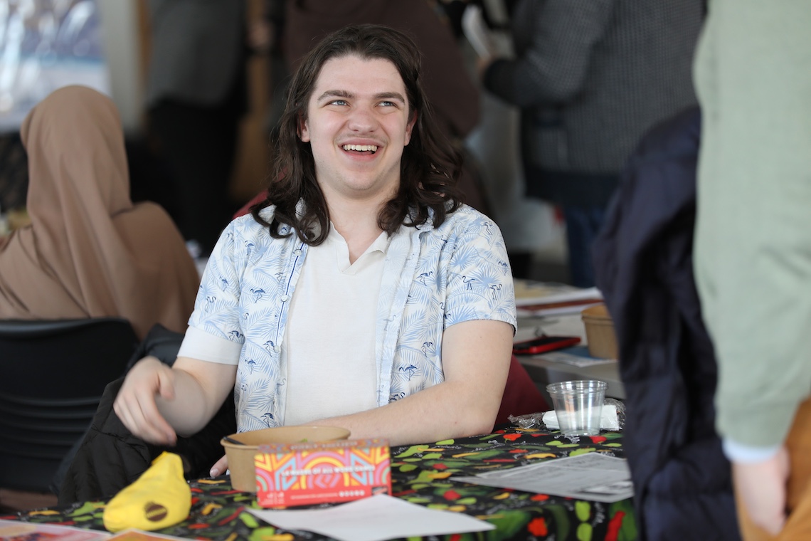 Spanish Club founder Jacob Beaulieu greets visitors to his table at the spring 2024 Multicultural Resource Fair.