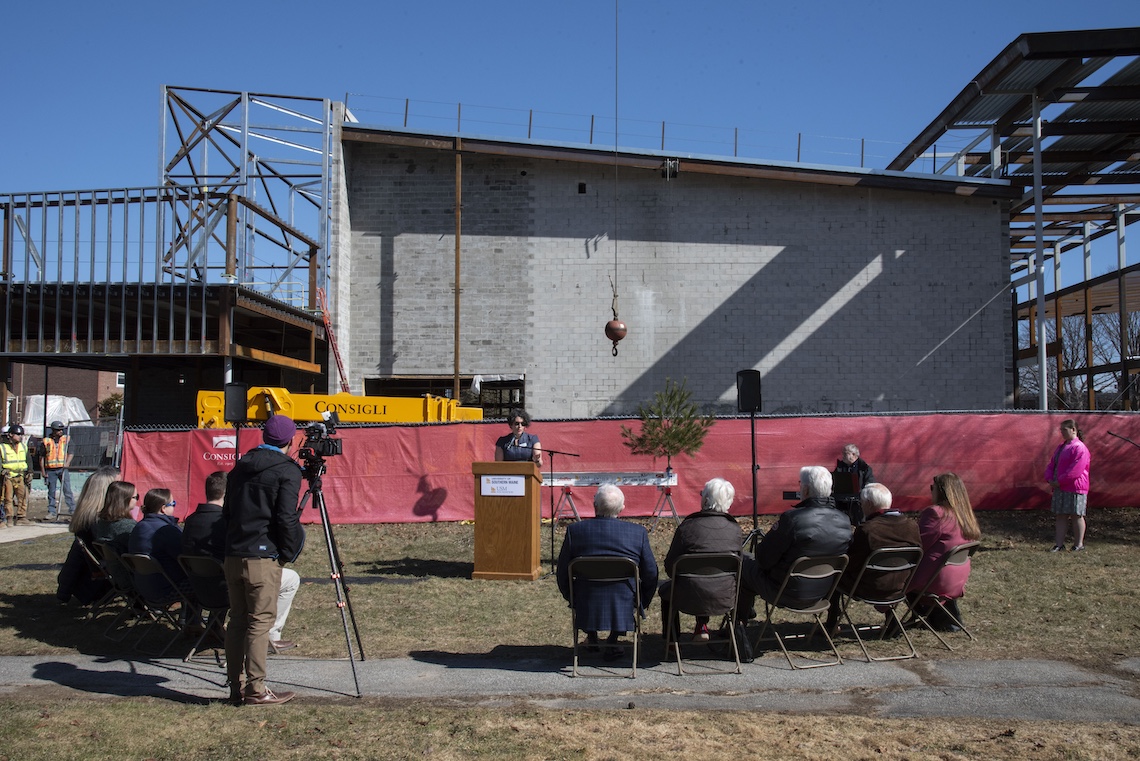 The framework of the new Crewe Center for the Arts cast shadows across Noyes Park during a ceremony to mark a construction milestone.