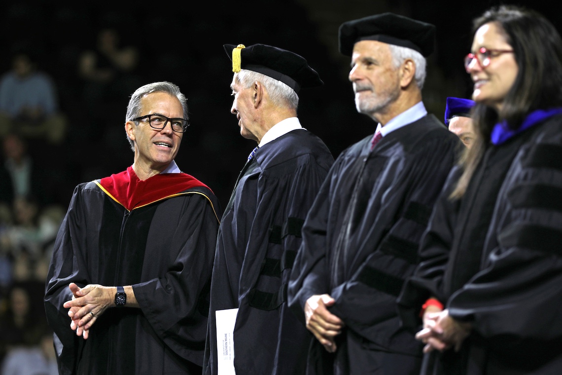 Tom Caron chats with the other honored guests at the 2024 Commencement ceremony.