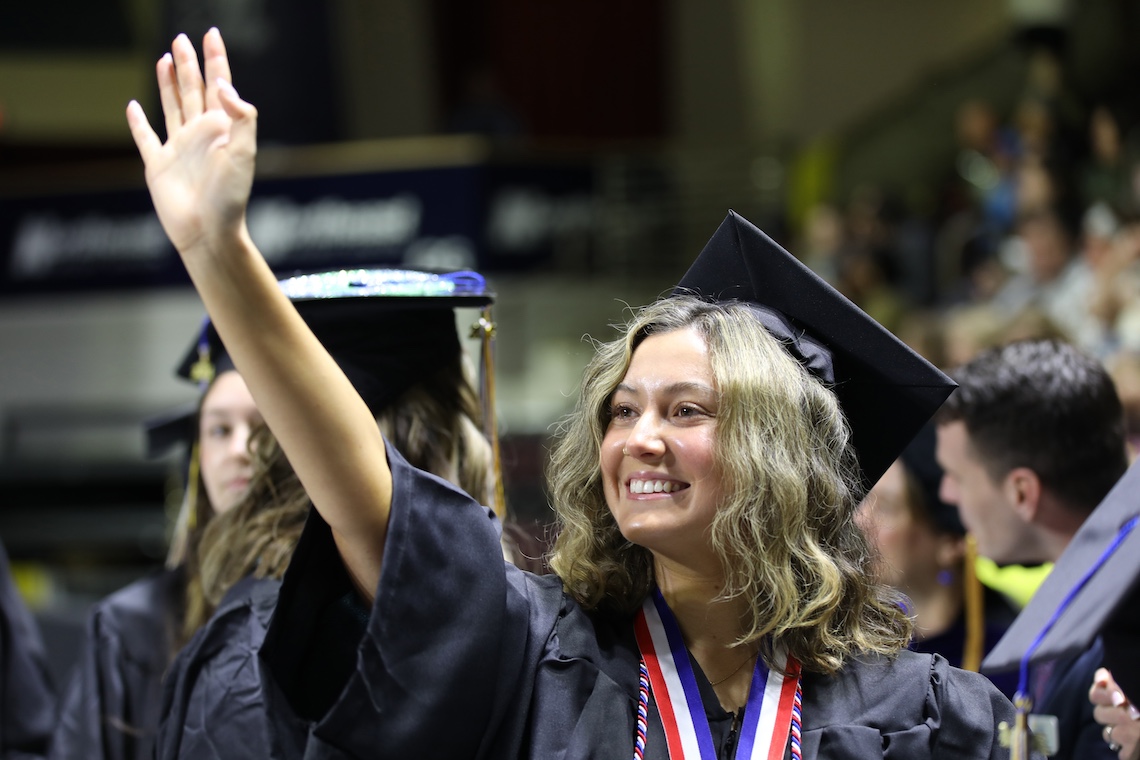 Graduates march one-by-one across the stage to receive their diplomas at the 2024 Commencement ceremony.