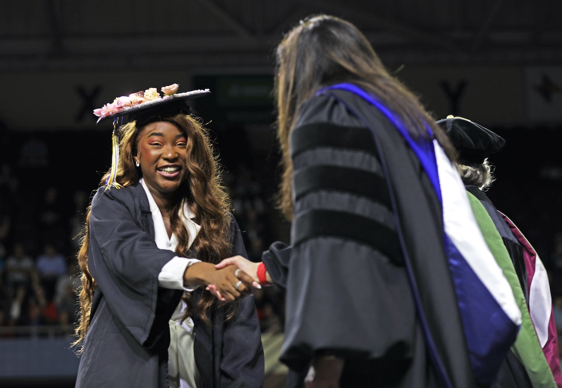Graduates march one-by-one across the stage to receive their diplomas at the 2024 Commencement ceremony.