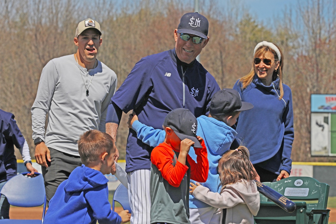 Hugs from his grandchildren bring out a smile in Coach Ed Flaherty at his retirement party.