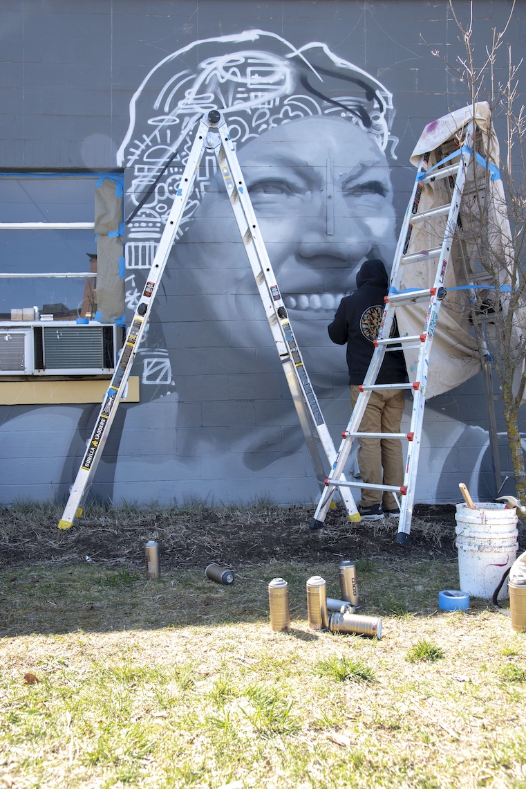 2024 artist-in-residence Ryan Adams paints a portrait of Pat Gallant-Charette as part of a mural in Westbrook.