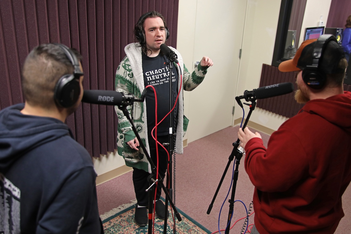 Three students lay down voice tracks in the new campus sound studio using equipment that once belonged to Bill Dufris.