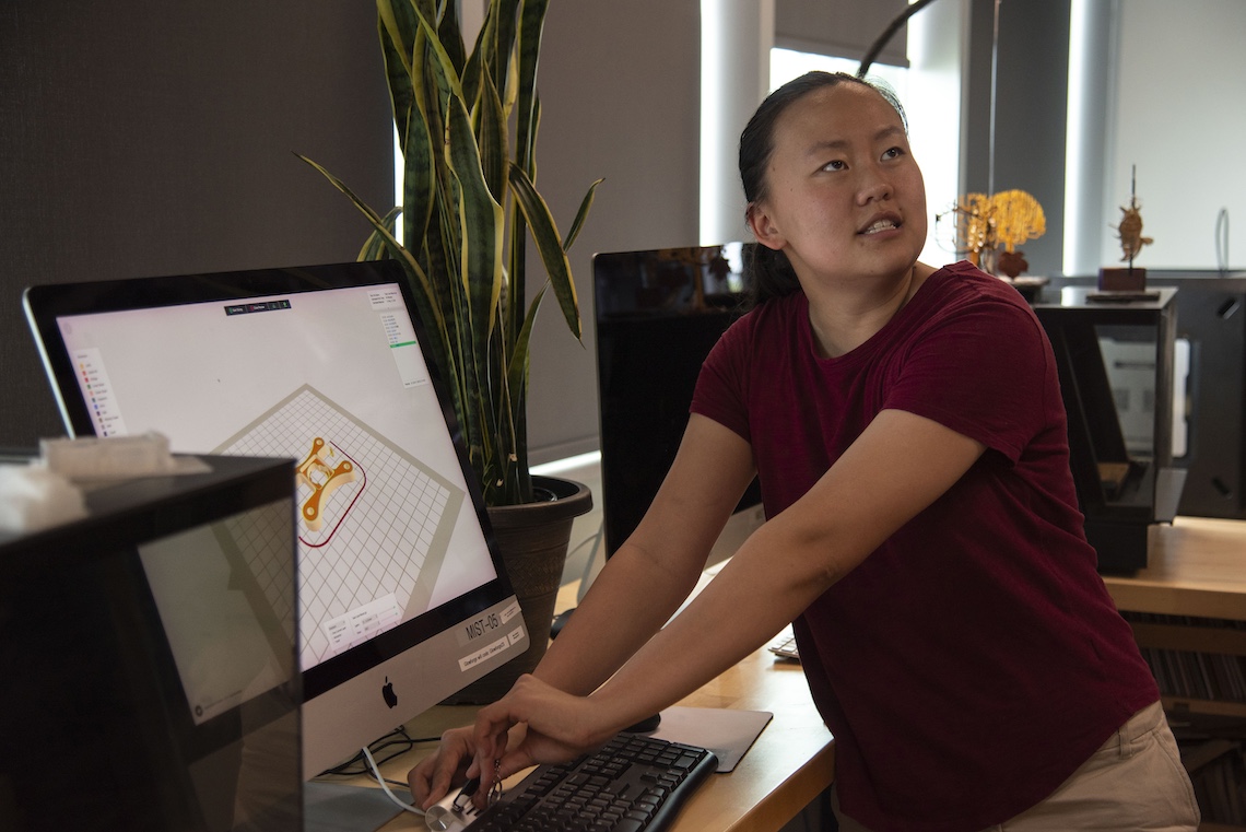 MIST Administrative Specialist Maya Twombly demonstrates the use of digital technology to conceptualize a locking device for the body-worn cameras used by Campus Police.