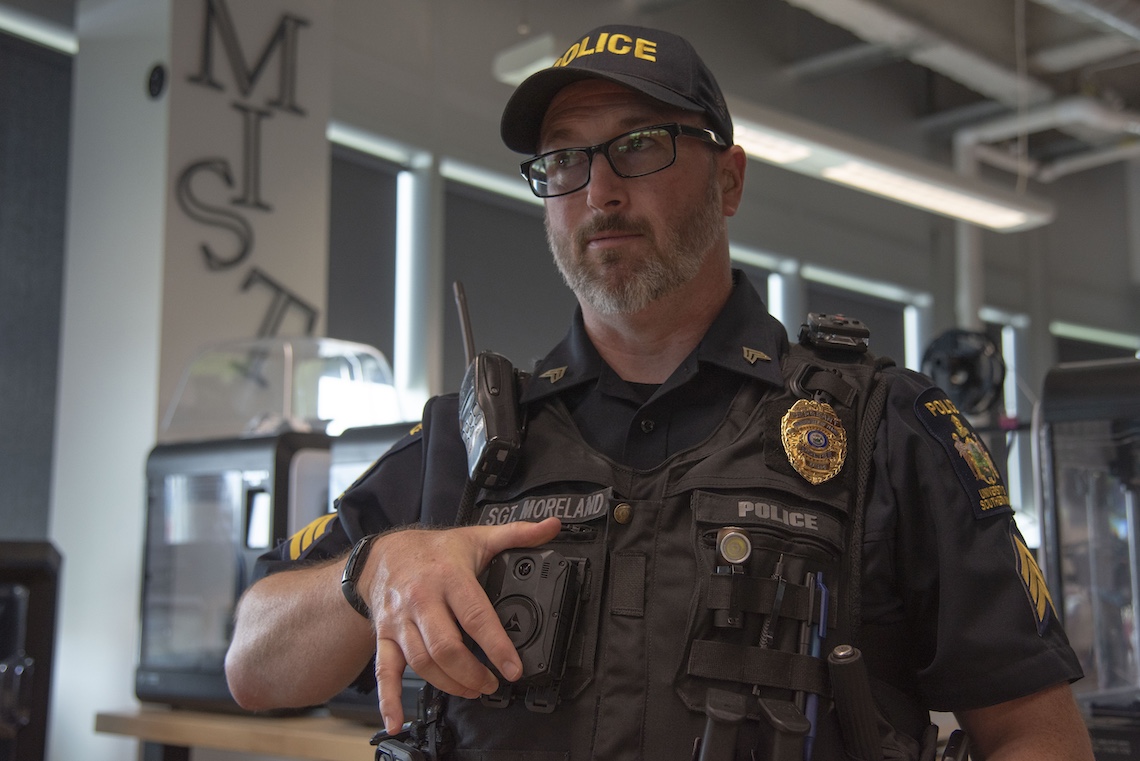 Sgt. Ben Moreland shows how a locking device made at the MIST Lab holds a body-worn camera securely to his MOLLE vest.