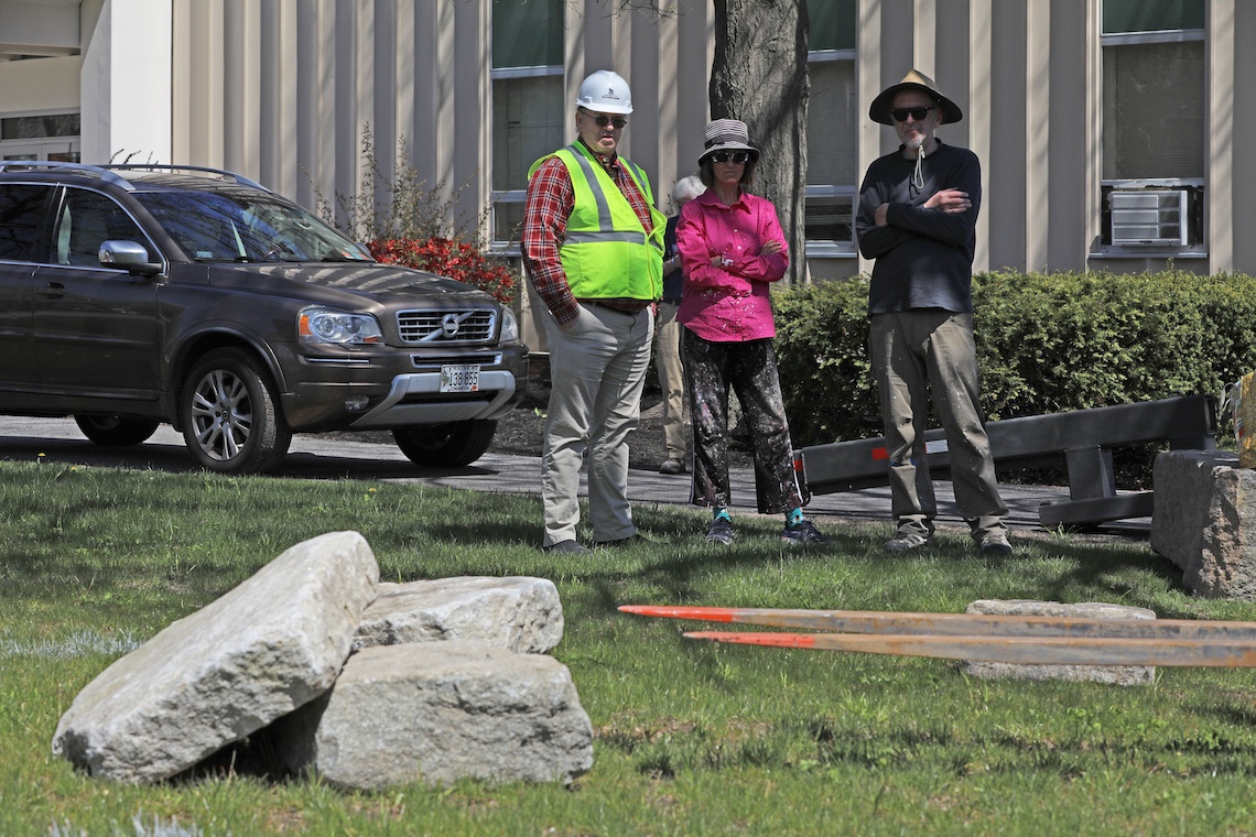 Artists Pamela Moulton and Roy Fox watch as a forklift delivers the stones that will serve as the foundation for their sculpture, TANGLE.