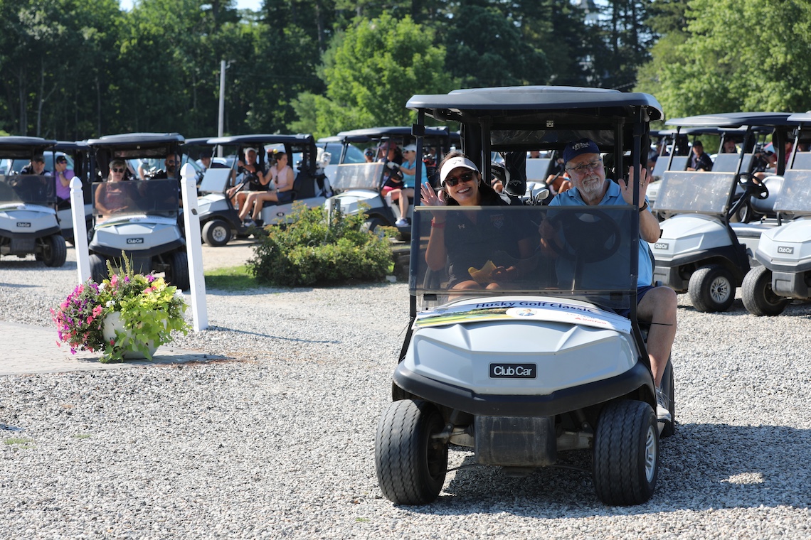 President Jacqueline Edmondson and her husband, Michael, set off in their cart to begin their round in the 2024 Husky Golf Classic.