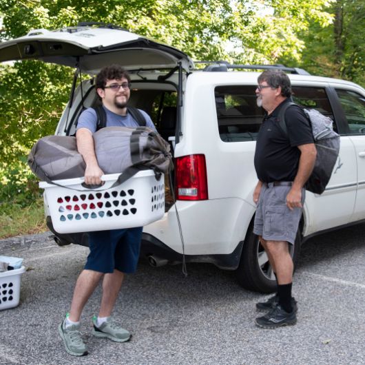 A new arrival to the Gorham Campus moves into his dorm one laundry basket at a time.