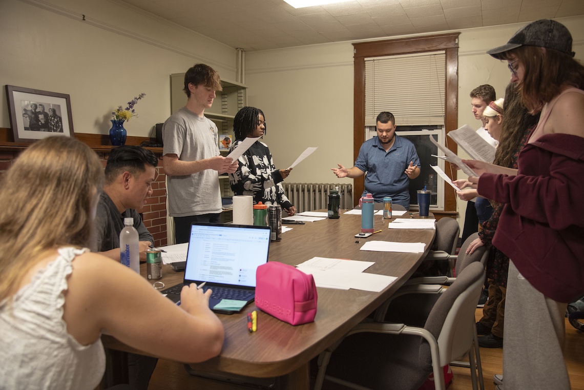 The cast of "The Wizard of Oz" radio play gathers around a table for a rehearsal.