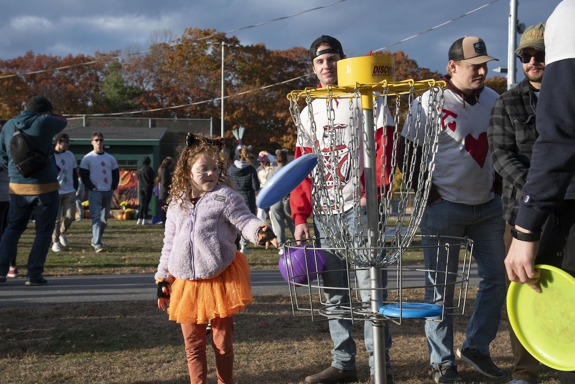 The men's ice hockey team coached kids at frisbee golf during the Husky Community Howl-o-Ween Party.