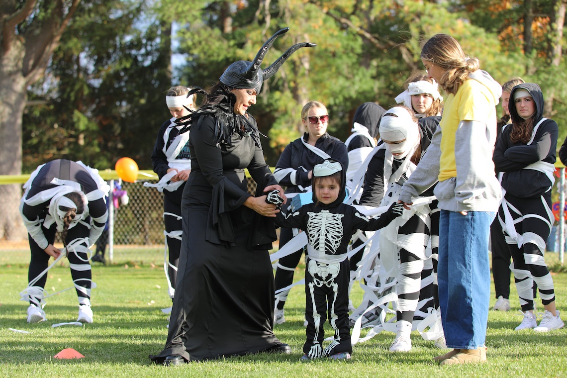 The softball team wrapped kids in toilet paper at a mummy-themed obstacle course during the Husky Community Howl-o-Ween Party.