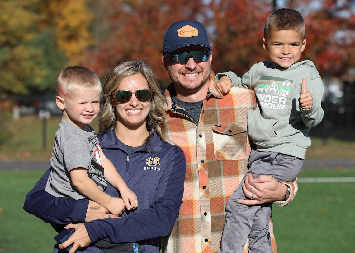 Peyton Dostie Collins celebrates her induction into the LEC Hall of Fame with her husband, Jeremy, and their sons, Hudson and Eli.