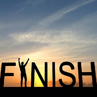 The word FINISH with a person standing in as the "I" in front of a sunset