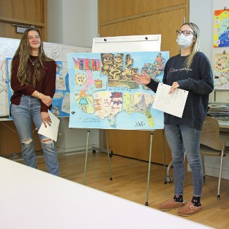 Students in Dr. Paula Gerstenblatt's master's level Social Work class explain the research that went into their allegorical map about the complexities of student loan debt.