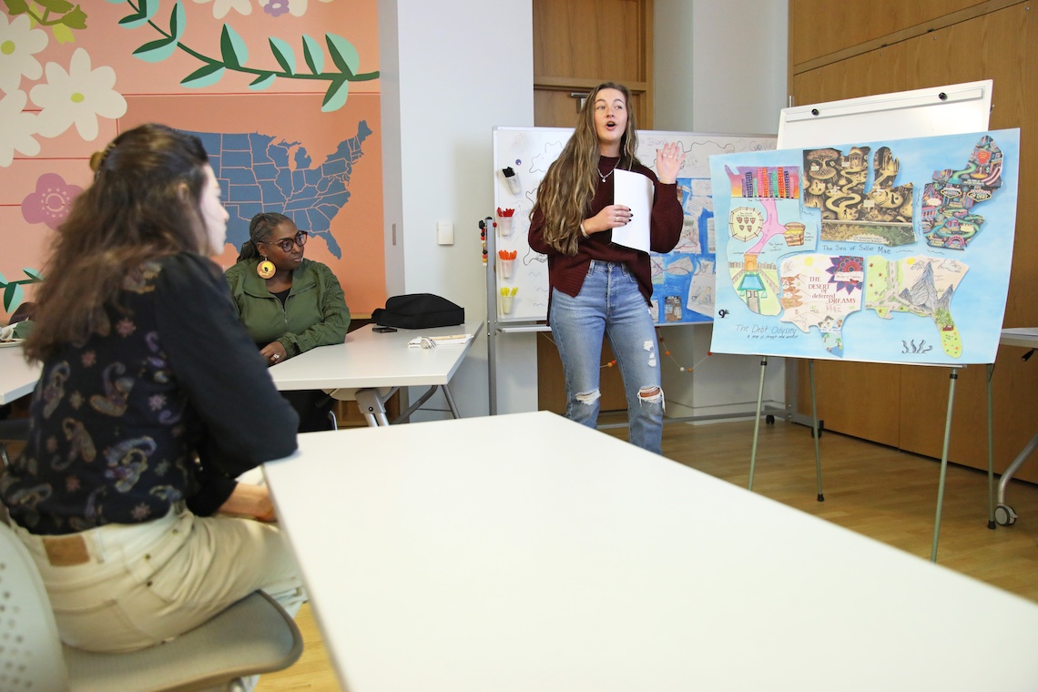 Ellen Karlberg explains the research behind the allegorical map about the complexities of student loan debt that she and her teammates created for a master's level Social Work class taught by Dr. Paula Gerstenblatt.