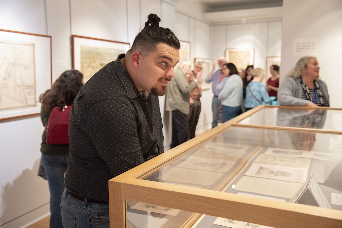 The crowd at the opening reception of the Osher Map Library's "A World On Display" exhibition was so big that visitors had to squeeze past each other through the gallery.