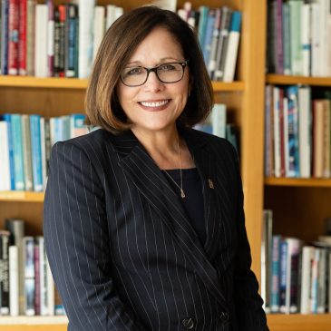 Jacqueline Edmondson posed in front of book shelf.