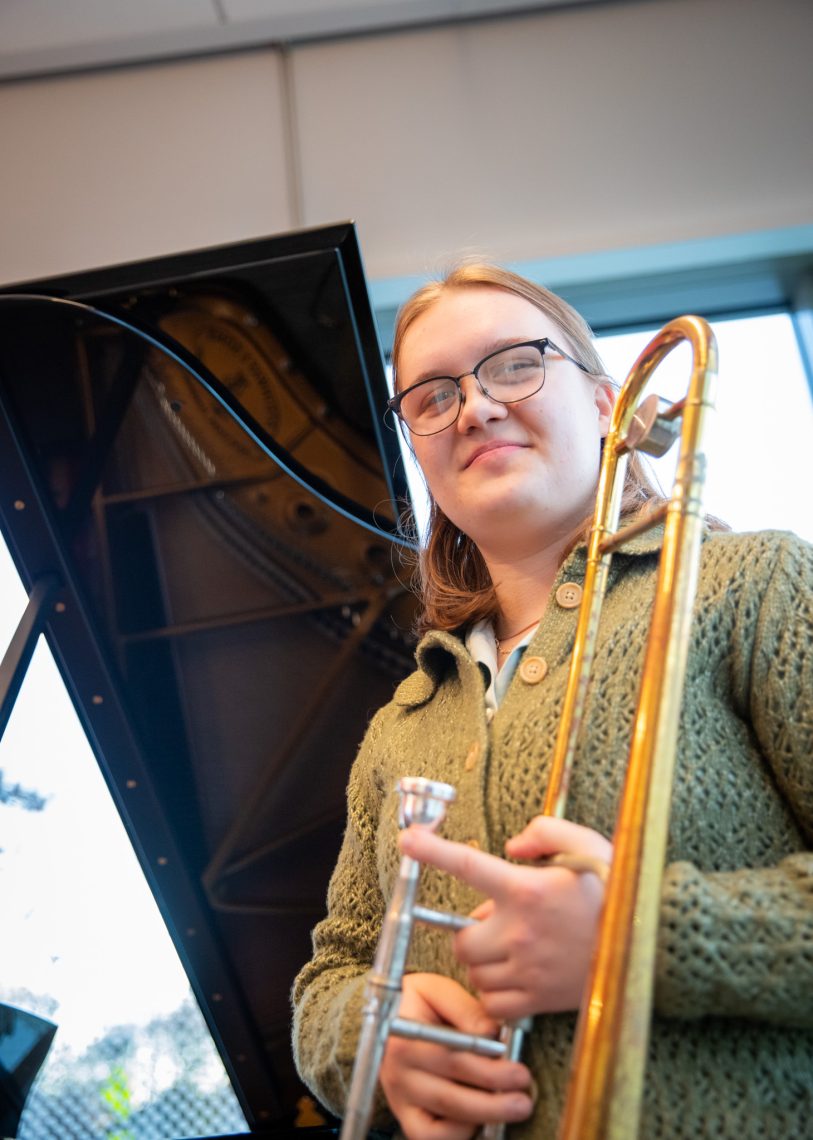 Soleil Haung-Dale in a rehearsal room with her trombone in the Crewe Center of the Arts.