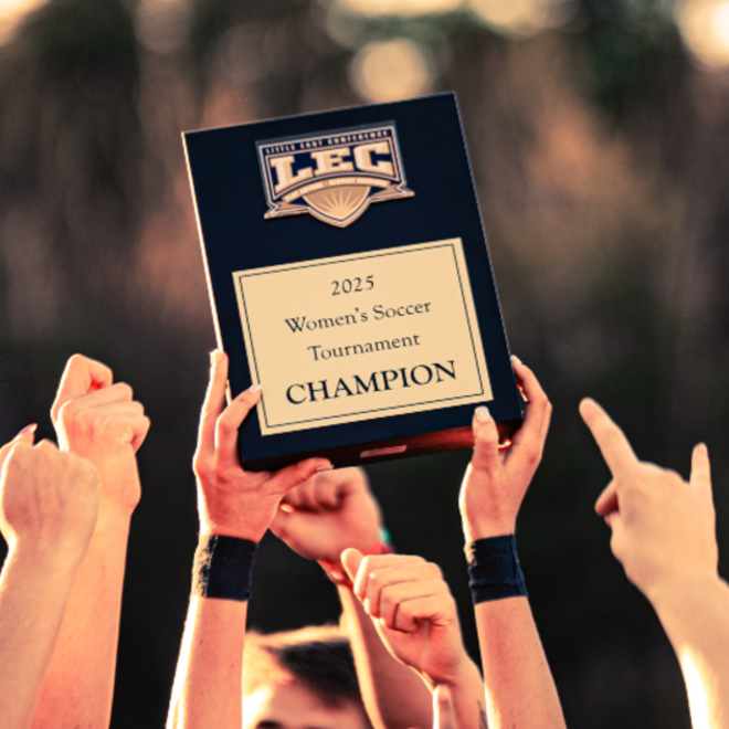 USM Women's soccer team players hold LEC conference title up in the air
