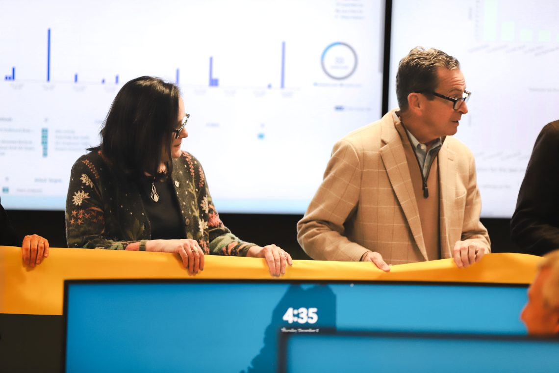President Edmondson and Chancellor Malloy hold the ribbon at new SOC Cybersecurity Classroom Ribbon Cutting.