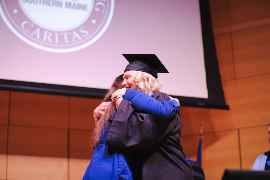 University of Southern Maine nursing graduate Michelle Lauture embraces daughter Simone Lauture after December 2024 pinning ceremony