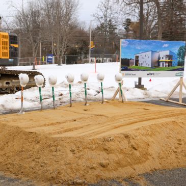 Shovels with hats on them stand in a row awaiting the ground breaking ceremony of the new Arts Building on the USM Gorham Campus.