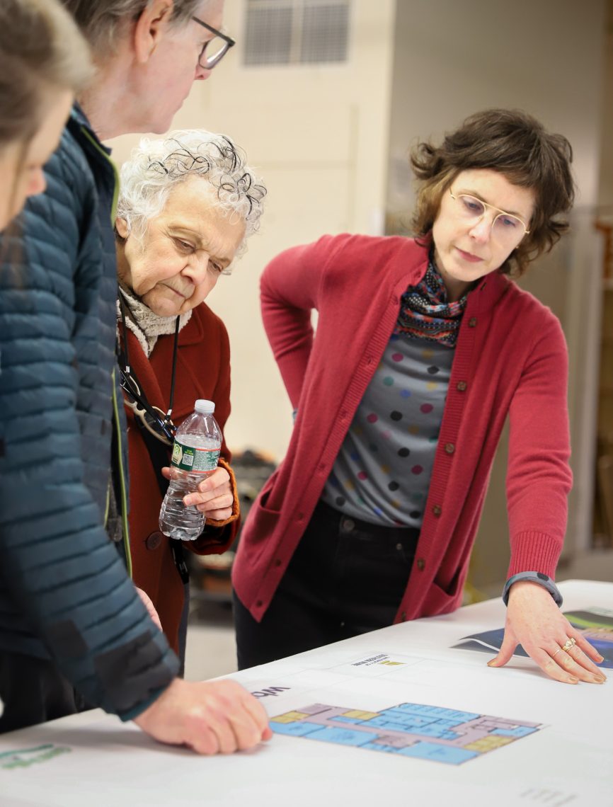 Hrenko, faculty, and community members observe the floorplan of the new Arts Building at the ground breaking reception.