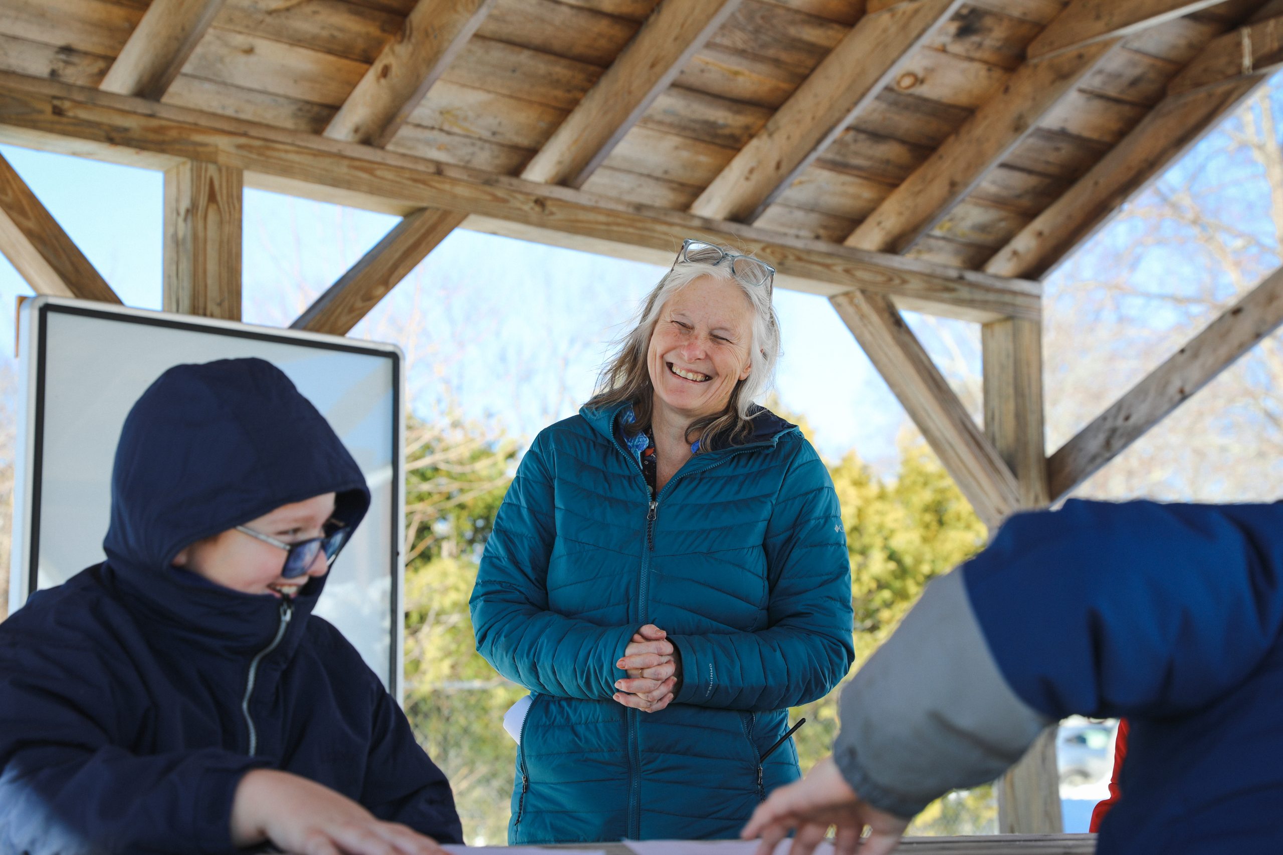 Becky Hallowell smiles while teaching students outside during a nature-based lesson at Wiscasset Elementary School.