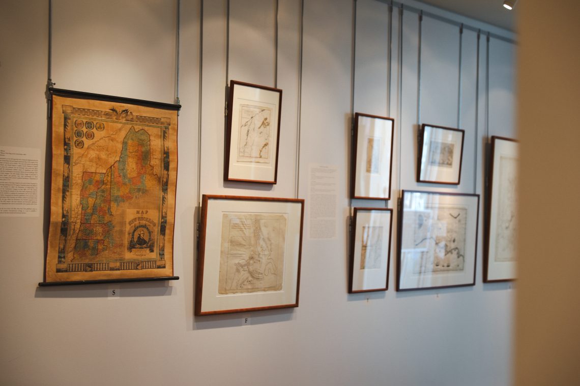 Hanging historical maps and prints displayed in the Osher Map Library’s Founding Memories: America at 250 exhibition.