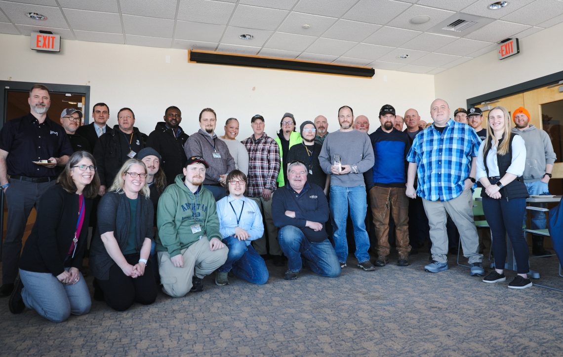 Group photo of FM Global representatives, University of Southern Maine facilities staff, and University of Maine System leaders standing together and smiling after the HPR award presentation on the Gorham campus.