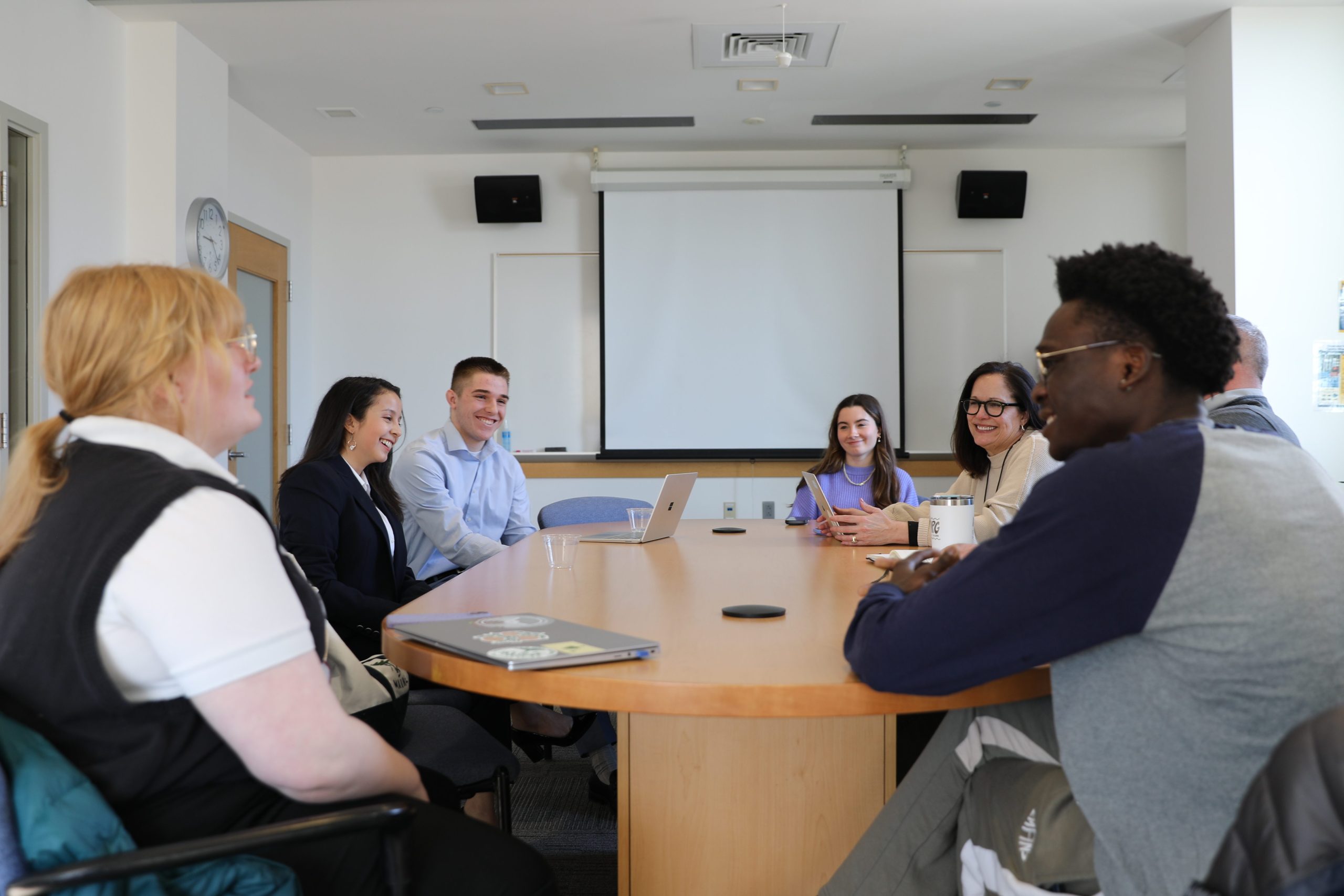 Forum on American Democracy scholars sit around a table with President Edmondson, engaged in discussion.