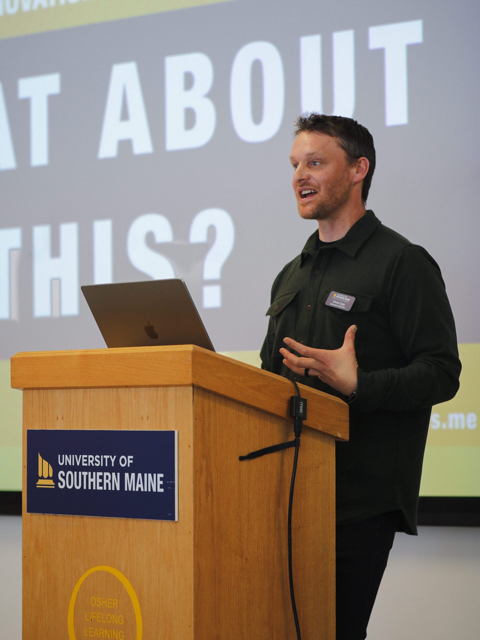 Chris Cary speaks to audience while hosting innovation challenge pitch event