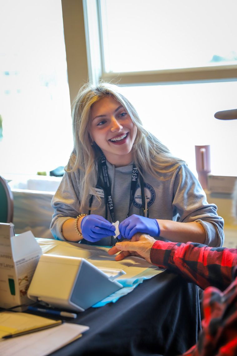 Meghan Mason prepping a local fisherman for a glucose screening.