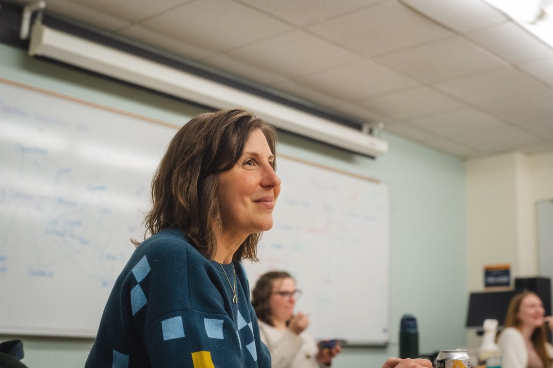 Professor listening attentively to students during a classroom discussion in a Polymath Pathway class.