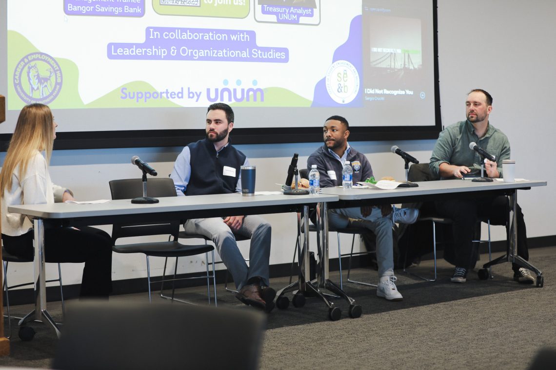 Photo of 4 panelists sitting behind a long table.
