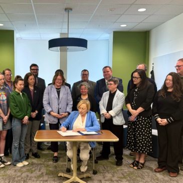 Governor Janet Mills signs bill regarding teacher pay surrounded students, legislators, and USM faculty