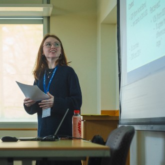 Student presenting from a slideshow at the front of a classroom