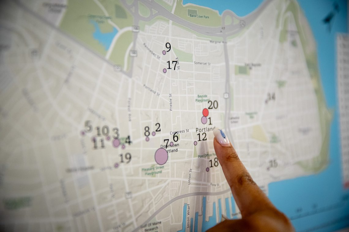 Attendee of mapping event pointing at a mark of interest on a map of Portland, Maine.