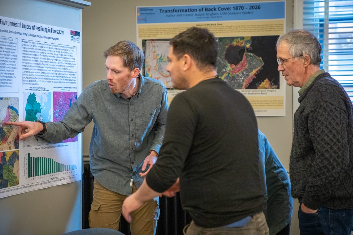 A GIS student talking through his map with attendees at First Friday Art Walk.