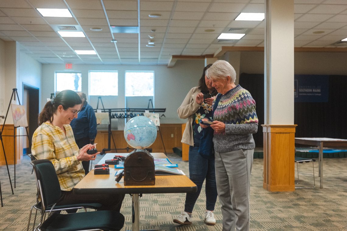Community members and faculty gather in the new Map Lab at the Lewiston-Auburn Campus.