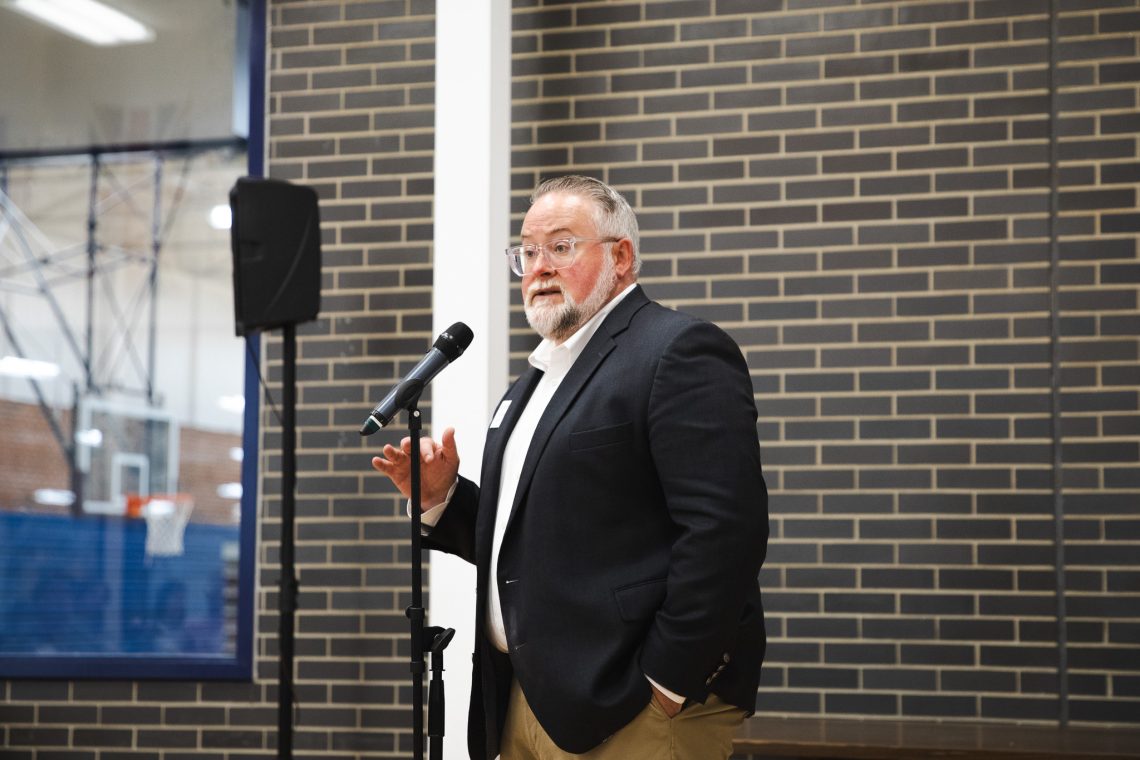 Andrew Pollom, vice president of student affairs at USM, speaks into a microphone while delivering remarks at the "Good People, Great Connections" networking event.