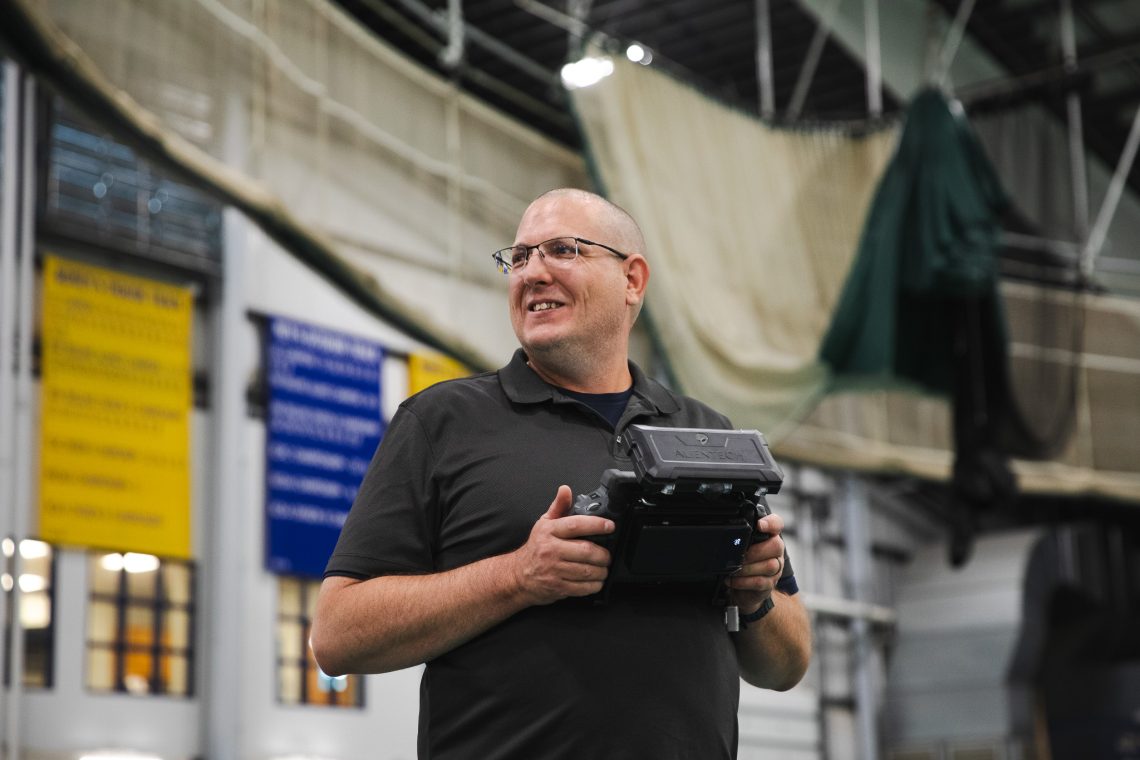 A participant pilots a drone using a handheld controller inside USM's Field House during a flight training session at the Response Ready: Public Safety UAS Conference.