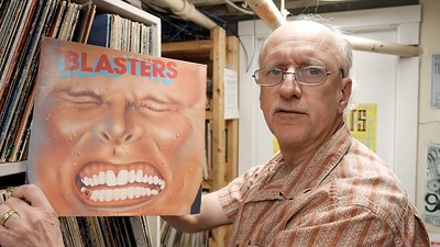 A still of a man holding "Blasters" vinyl from WMPG documentary "An Extraordinary Place".