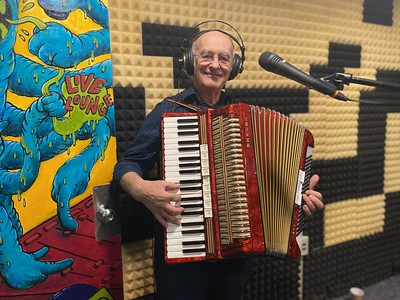 A still of a man playing accordion from WMPG documentary "An Extraordinary Place".