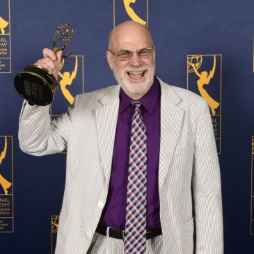Tom Bell holding his New England Emmy for "An Extraordinary Place".